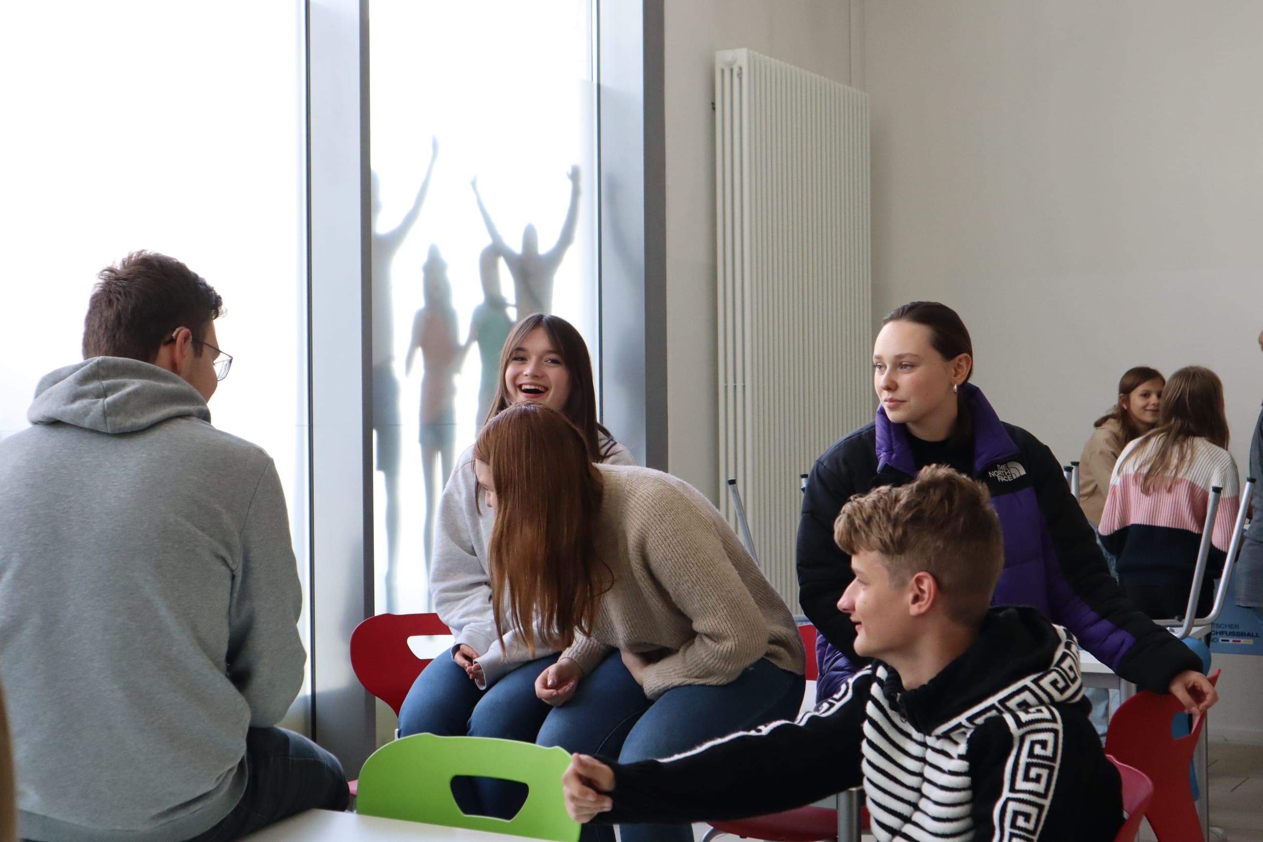 Lachende Schülerinnen und Schüler der wikawi in einem hellen Klassenraum